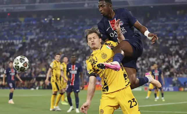 PSG's Willian Pacho kicks the ball by Inter Milan's Nicolo Barella during the Champions League final soccer match between Paris Saint-Germain and Inter Milan at the Allianz Arena in Munich, Germany, Saturday, May 31, 2025. (AP Photo/Alexandra Beier)