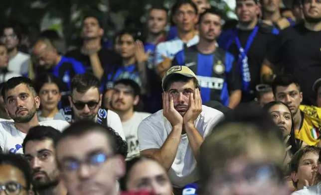 Inter Milan fans react as they watch their team play PSG in the Champions League final soccer match in open pub in Milan, Italy, Saturday, May 31, 2025. (AP Photo/Antonio Calanni)