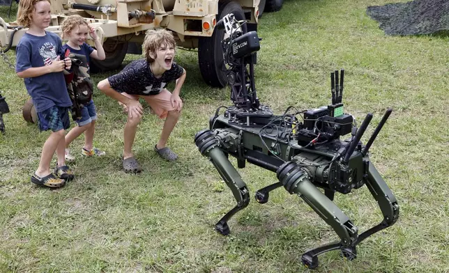 "Lone Wolf" a military robotic dog interacts with visitors at the America 250 Celebration at Fort Bragg in Fayetteville, N.C., Tuesday, June 10, 2025. (AP Photo/Karl DeBlaker)