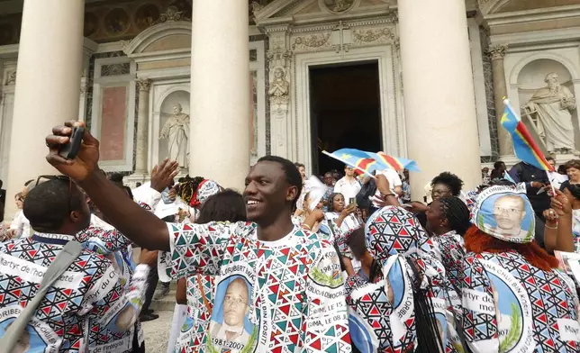 Faithful celebrate at the end of a ceremony for the beatification of Floribert Bwana Chui Bin Kositi, a Congolese man killed in 2007 for fighting corruption, in St. Paul Outside the Walls' Basilica, in Rome, Sunday, June 15, 2025. (AP Photo/Riccardo De Luca)
