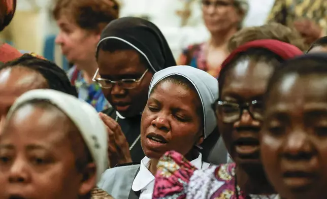 Faithful pray during a ceremony for the beatification of Floribert Bwana Chui Bin Kositi, a Congolese man killed in 2007 for fighting corruption, in St. Paul Outside the Walls' Basilica, in Rome, Sunday, June 15, 2025. (AP Photo/Riccardo De Luca)