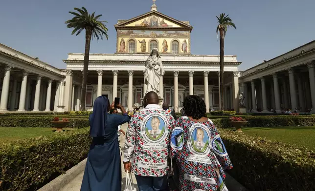 Faithful arrive for the beatification ceremony of Floribert Bwana Chui Bin Kositi, a Congolese man killed in 2007 for fighting corruption, in St. Paul Outside the Walls' Basilica, in Rome, Sunday, June 15, 2025. (AP Photo/Riccardo De Luca)