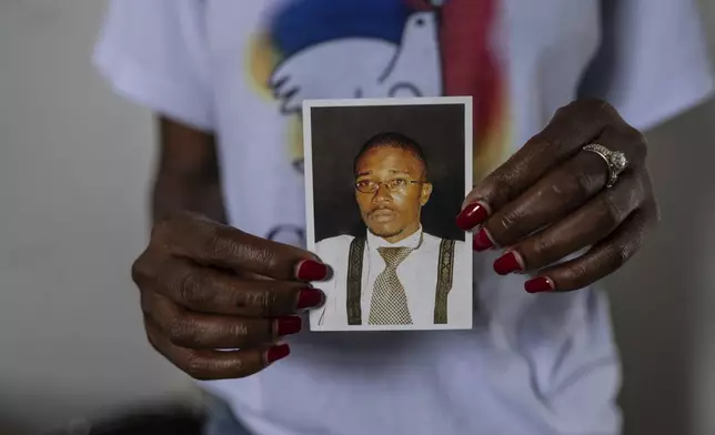 FILE - Aline Minani holds a photo of Floribert Bwana Chui Bin Kositi, a Congolese man killed for fighting corruption in 2007, and whose beatification was approved by Pope Francis, in Goma, Democratic Republic of Congo, Dec. 29, 2024. (AP Photo/Moses Sawasawa, File)