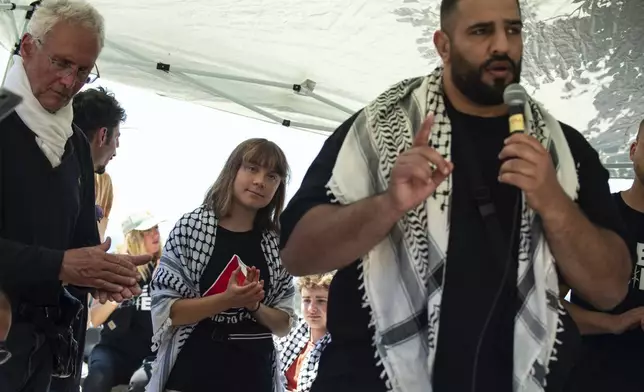 Climate activist Greta Thunberg listens to Doctor Mohammed Mustafa, right, from the Freedom Flotilla human rights organization talking to journalists ahead of their departure for the Mideast, in Catania, Italy, Sunday, June 1, 2025. (AP Photo/Salvatore Cavalli)