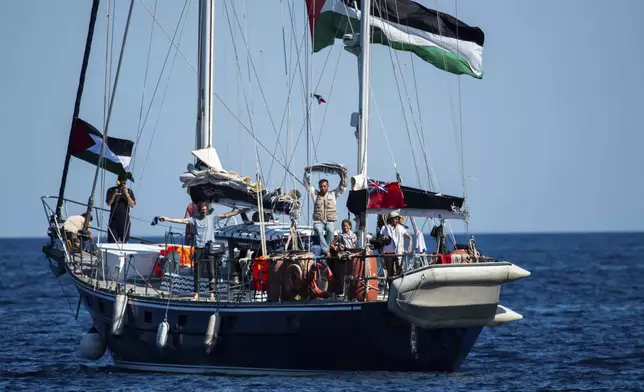 Activists of the Freedom Flotilla Coalition, board the Madleen boat, ahead of setting sail for Gaza, departing from the Sicilian port of Catania, Italy, Sunday, June 1, 2025. (AP Photo/Salvatore Cavalli)