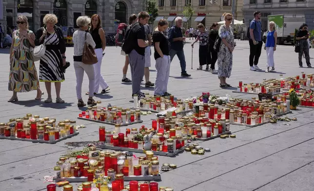 People commemorate the victims of a shooting at a school, where a former student opened fire two days before, at the central square in Graz, Austria, Thursday, June 12, 2025. (AP Photo/Darko Bandic)