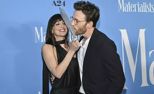 Chris Evans, right, kisses a Pedro Pascal head cutout held by Dakota Johnson at the premiere of "Materialists" at the DGA New York Theater on Saturday, June 7, 2025, in New York. (Photo by Evan Agostini/Invision/AP)