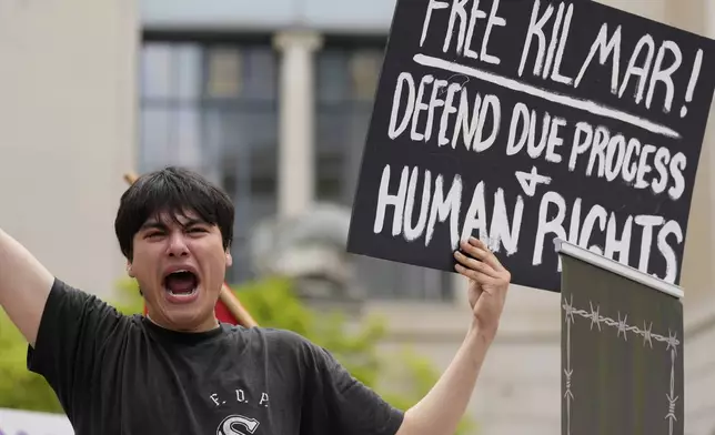Tiki Osiris holds a sign as protesters gather outside the Federal Courthouse before arguments whether Kilmar Abrego Garcia can be released from jail on Friday, June 13, 2025 in Nashville, Tenn. (AP Photo/George Walker IV)