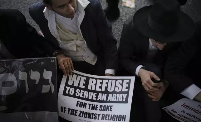 Ultra-Orthodox Jewish men block a highway during a protest against army recruitment in Bnei Brak, Israel, Thursday, June 5, 2025. (AP Photo/Leo Correa)