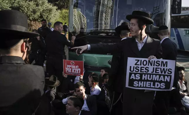 Ultra-Orthodox Jewish men block a highway during a protest against army recruitment in Bnei Brak, Israel, Thursday, June 5, 2025. (AP Photo/Leo Correa)