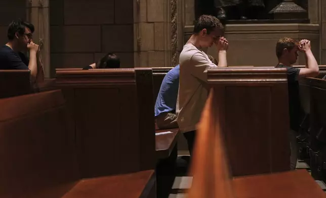 Eric Anderson, center, an associate campus minister at Princeton University prays with others, including Logan Nelson, right, a fellow member of the university’s Catholic campus ministry, after a Mass on Friday, May 16, 2025. (AP Photo/Luis Andres Henao)