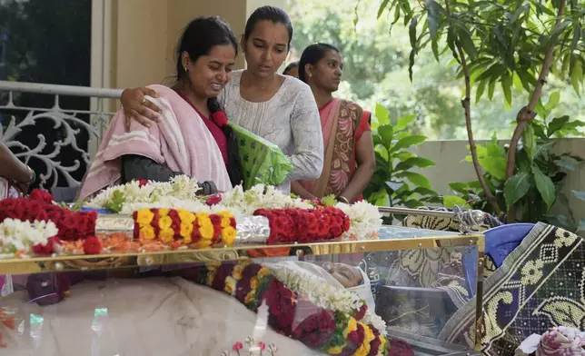 A relative cries next to the body of 14-year-old Divyanshi Shivakumar, who lost her life in Wednesday's deadly stampede during celebrations outside a stadium for Royal Challengers Bengaluru, winners of the Indian Premier League, at her residence ahead of her last rites in Bengaluru, India, Thursday, June 5, 2025. (AP Photo/Aijaz Rahi)