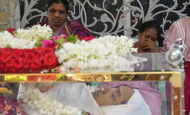 Relatives mourn next to the body of 14-year-old Divyanshi Shivakumar, who lost her life in Wednesday's deadly stampede during celebrations outside a stadium for Royal Challengers Bengaluru, winners of the Indian Premier League, at her residence ahead of her last rites in Bengaluru, India, Thursday, June 5, 2025. (AP Photo/Aijaz Rahi)