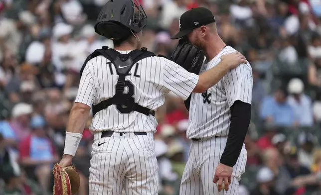 Chicago White Sox catcher Kyle Teel, left, talks with relief pitcher Cam Booser during the eighth inning in the first baseball game of a doubleheader against the St. Louis Cardinals, Thursday, June 19, 2025. (AP Photo/Nam Y. Huh)