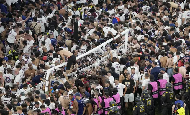 Fans of PSG invade the pitch after the Champions League final soccer match between Paris Saint-Germain and Inter Milan at the Allianz Arena in Munich, Germany, Saturday, May 31, 2025. (AP Photo/Michael Probst)