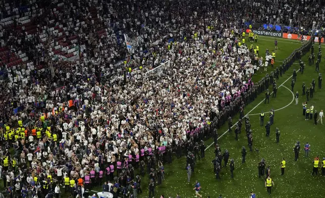 Fans of PSG invade the pitch after the Champions League final soccer match between Paris Saint-Germain and Inter Milan at the Allianz Arena in Munich, Germany, Saturday, May 31, 2025. (AP Photo/Michael Probst)
