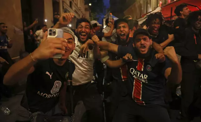 PSG supporters celebrate in a street during the Champions League final soccer match between Paris Saint-Germain and Inter Milan, Saturday, May 31, 2025 in Paris. (AP Photo/Thomas Padilla)