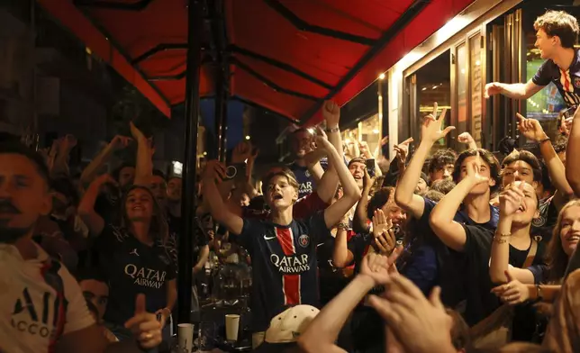 PSG supporters celebrate one of their team's goal outside a cafe during the Champions League final soccer match between Paris Saint-Germain and Inter Milan, Saturday, May 31, 2025 in Paris. (AP Photo/Thomas Padilla)