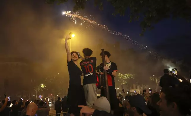 PSG supporters celebrate during the Champions League final soccer match between Paris Saint-Germain and Inter Milan, Saturday, May 31, 2025 in Paris. (AP Photo/Thomas Padilla)