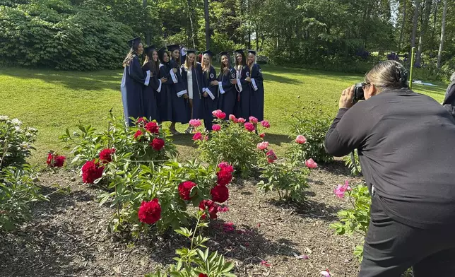 Soon-to-be high school graduates pose for photos among the peonies at Nichols Arboretum's W.E. Upjohn Peony Garden, Monday, June 2, 2025, in Ann Arbor, Mich. (AP Photo/Mike Householder)