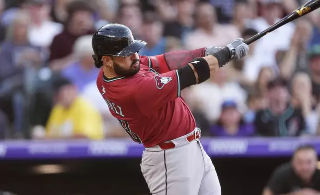 Arizona Diamondbacks' Eugenio Suárez singles off Colorado Rockies starting pitcher Austin Gomber in the third inning of a baseball game Friday, June 20, 2025, in Denver. (AP Photo/David Zalubowski)