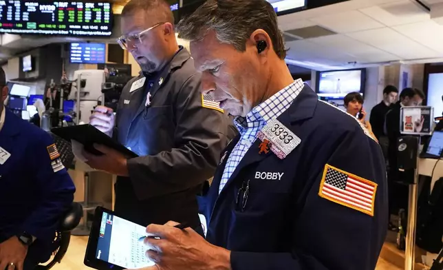 Traders Ryan Falvey, left, and Robert Charmak work on the floor of the New York Stock Exchange, Friday, June 27, 2025. (AP Photo/Richard Drew)