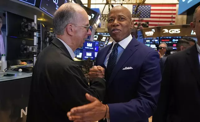 Trader Joe Dente, left, meets New York Mayor Eric Adams on the floor of the New York Stock Exchange after Adams was interviewed on CNBC, Friday, June 27, 2025. (AP Photo/Richard Drew)