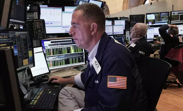Trader Justin Flinn, left, works on the floor of the New York Stock Exchange, Friday, June 27, 2025. (AP Photo/Richard Drew)