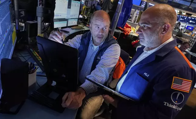 Trades Peter Mancuso, left, and Phil Quartuccio work on the floor of the New York Stock Exchange, Friday, June 27, 2025. (AP Photo/Richard Drew)