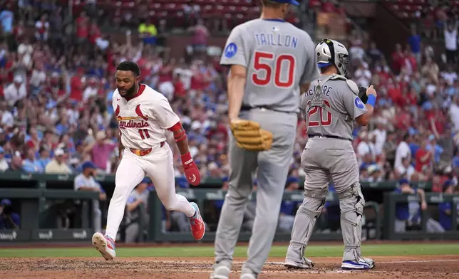 St. Louis Cardinals' Victor Scott II (11) scores past Chicago Cubs starting pitcher Jameson Taillon (50) and catcher Reese McGuire during the fourth inning of a baseball game Tuesday, June 24, 2025, in St. Louis. (AP Photo/Jeff Roberson)