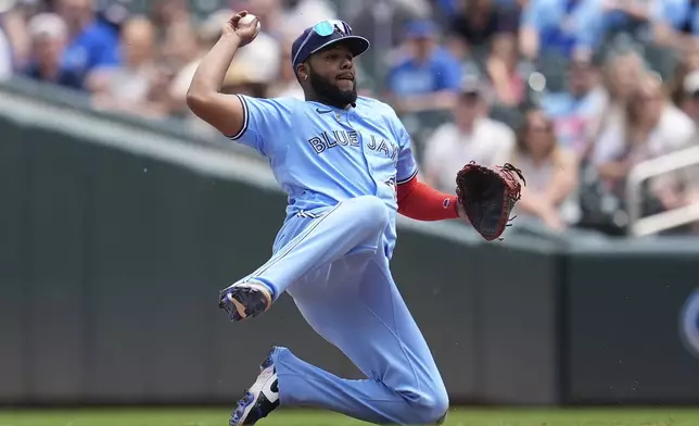 Toronto Blue Jays first baseman Vladimir Guerrero Jr. (27) throws to first base for the out on Minnesota Twins' Trevor Larnach during the fifth inning of a baseball game Saturday, June 7, 2025, in Minneapolis. (AP Photo/Abbie Parr)