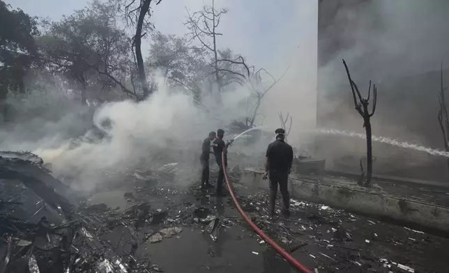 Firefighters work at the site of an airplane that crashed in India's northwestern city of Ahmedabad in Gujarat state, Thursday, June 12, 2025. (AP Photo/Ajit Solanki)