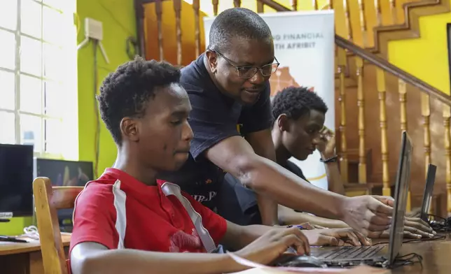The AFRIBIT co-founder Ronnie Mdawida interacts with students learning bitcoin technology at Afribit offices on the outskirts of Kibera Slums in Nairobi, Kenya, Sunday, May 4, 2025. (AP Photo/Andrew Kasuku)