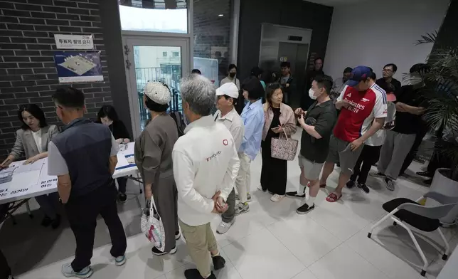 People wait in line to cast their votes for the presidential election at a polling station in Seoul, South Korea, Tuesday, June 3, 2025. (AP Photo/Ahn Young-joon)