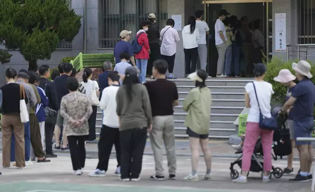 People wait in line to cast their votes for the presidential election at a polling station in Seoul, South Korea, Tuesday, June 3, 2025. (AP Photo/Lee Jin-man)