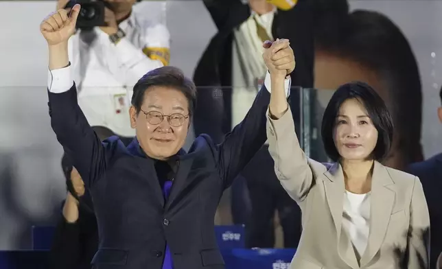 South Korea's Democratic Party's presidential candidate Lee Jae-myung, and his wife Kim Hea Kyung, greet supporters outside of the National Assembly in Seoul, South Korea, Wednesday, June 4, 2025. (AP Photo/Lee Jin-man)