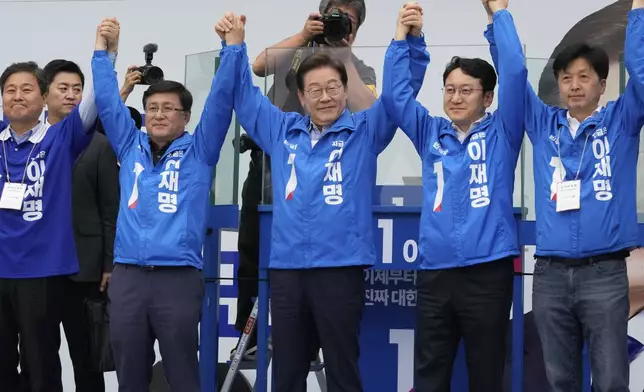 South Korea's Democratic Party's presidential candidate Lee Jae-myung, center, raises his hands with his party members during a presidential election campaign in Seoul, South Korea, Monday, June 2, 2025. (AP Photo/Ahn Young-joon)