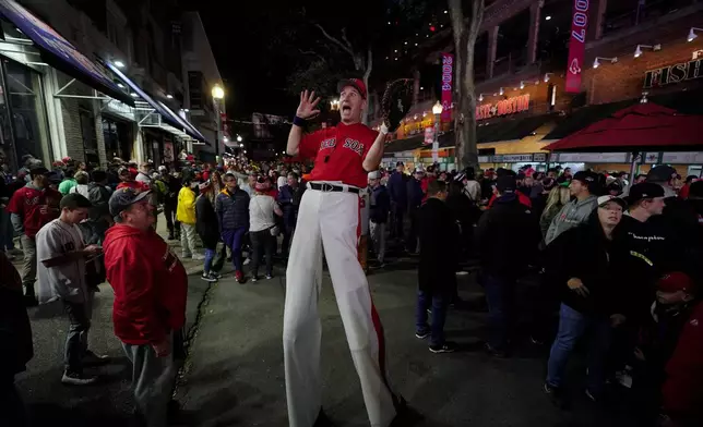 FILE-A street performer entertains the crowd outside Fenway Park in this Oct. 19, 2021 file photo in Boston.(AP Photo/Robert F. Bukaty, files)