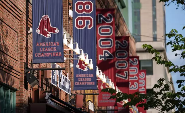 Banners commemorating League Championships and World Series titles hang outside Fenway Park, Monday, June 2, 2025, in Boston. (AP Photo/Robert F. Bukaty)