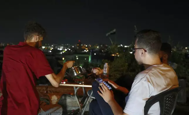 Syrian citizens gather at a public park, as they wait to watch the Iranian missiles fired against Israel to pass over Damascus airspace, Syria, Monday, June 16, 2025. (AP Photo/Omar Sanadiki)