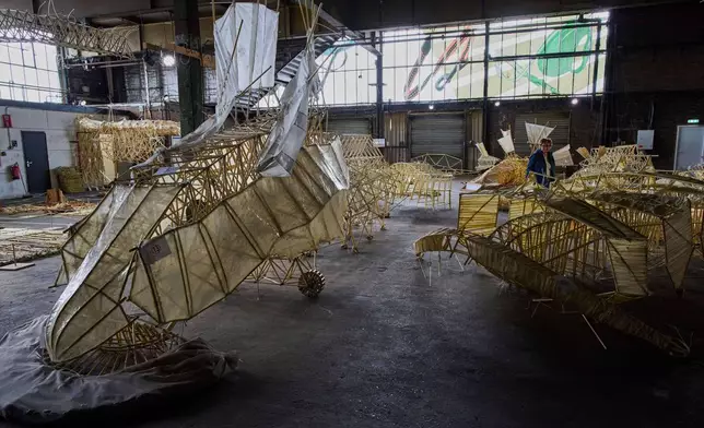 Dutch artist Theo Jansen's 'strandbeesten' or Beach Beasts, wind-powered creatures made from yellow plastic tubes, are displayed during an exhibit in Delft, Netherlands, Thursday, June 5, 2025. (AP Photo/Peter Dejong)
