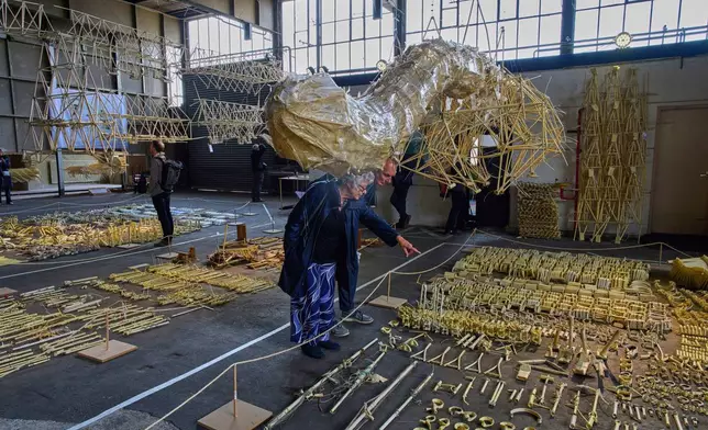 Dutch artist Theo Jansen's 'strandbeesten' or Beach Beasts, wind-powered creatures made from yellow plastic tubes, are displayed during an exhibit in Delft, Netherlands, Thursday, June 5, 2025. (AP Photo/Peter Dejong)