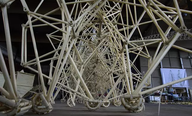 Dutch artist Theo Jansen's 'strandbeesten' or Beach Beasts, wind-powered creatures made from yellow plastic tubes, are displayed during an exhibit in Delft, Netherlands, Thursday, June 5, 2025. (AP Photo/Peter Dejong)