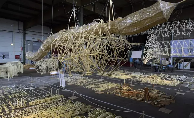 Dutch artist Theo Jansen's 'strandbeesten' or Beach Beasts, wind-powered creatures made from yellow plastic tubes, are displayed during an exhibit in Delft, Netherlands, Thursday, June 5, 2025. (AP Photo/Peter Dejong)