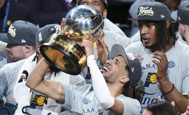 Indiana Pacers guard Tyrese Haliburton holds up the trophy after the Pacers won Game 6 of the Eastern Conference finals of the NBA basketball playoffs against the New York Knicks in Indianapolis, Saturday, May 31, 2025. (AP Photo/AJ Mast)