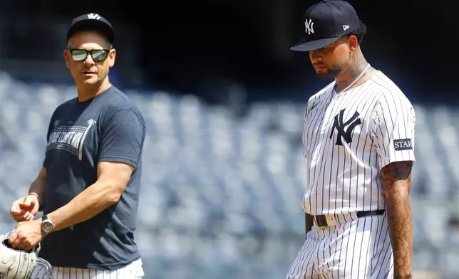 New York Yankees' manager Aaron Boone and Luis Gil talk during live batting practice before a baseball game against the Baltimore Orioles, Saturday, June 21, 2025, in New York. (AP Photo/Noah K. Murray)