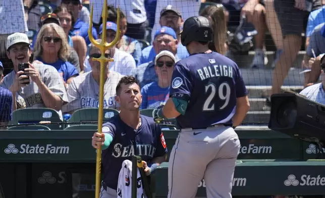 Seattle Mariners' Cal Raleigh (29), right, receives the home run trident from Dylan Moore (25) after hitting a home run during the first inning of a baseball game against the Chicago Cubs, Friday, June 20, 2025, in Chicago. (AP Photo/Erin Hooley)