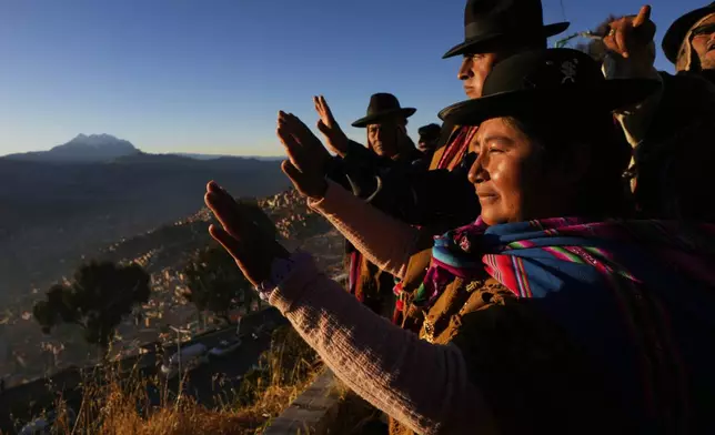 Aymara Indigenous people hold up their hands to receive the first rays of sunlight in celebration of the Andean New Year 5533 marking the Southern Hemisphere's winter solstice, in El Alto, Bolivia, Saturday, June 21, 2025. (AP Photo/Juan Karita)