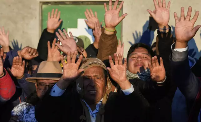 Aymara Indigenous people hold up their hands to receive the first rays of sunlight in celebration of the Andean New Year 5533 marking the Southern Hemisphere's winter solstice, in El Alto, Bolivia, Saturday, June 21, 2025. (AP Photo/Juan Karita)
