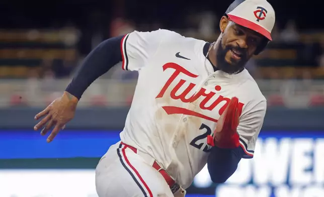 Minnesota Twins' Byron Buxton rounds third base en route to scoring on a single by Willi Castro against the Seattle Mariners in the sixth inning of a baseball game Wednesday, June 25, 2025, in Minneapolis. (AP Photo/Bruce Kluckhohn)